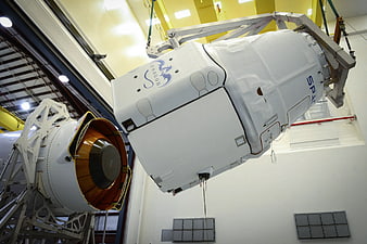 SpaceX Dragon spacecraft suspended in assembly facility