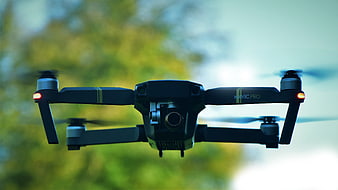DJI Mavic Pro Drone In Flight Against Blurred Green Nature Background