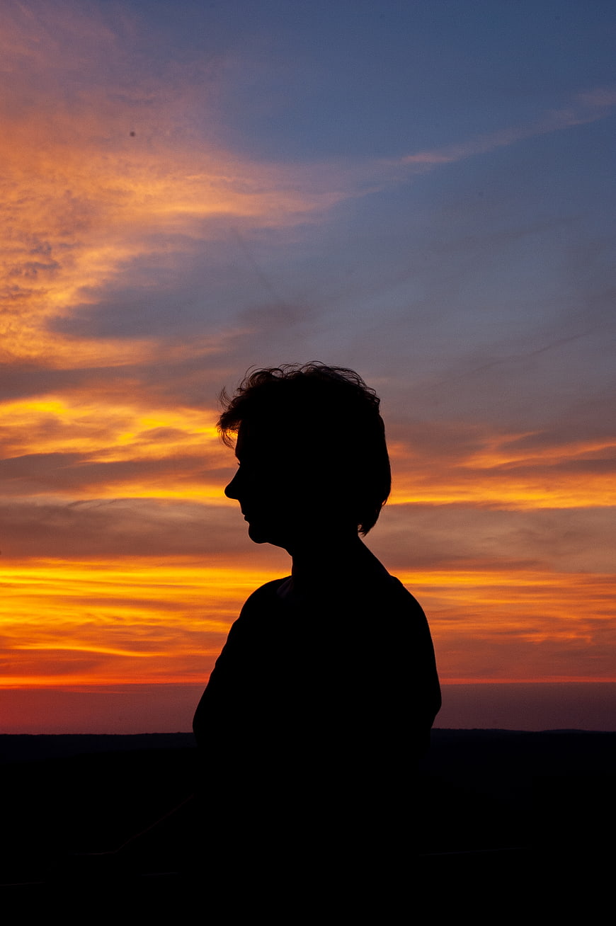 Silhouette of Woman Against Dramatic Sunset Sky