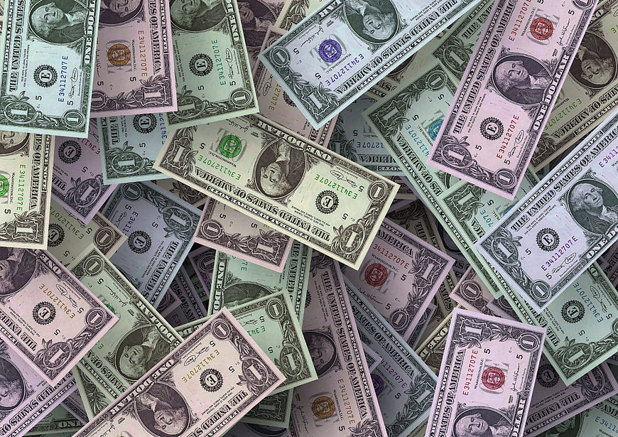 Scattered pile of one dollar bills background