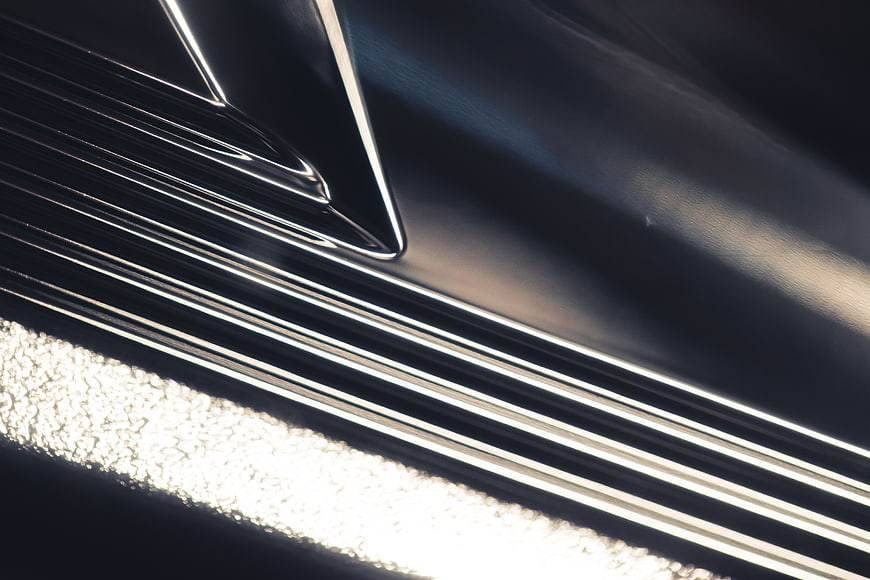 Close-up of shiny metallic surface with chrome lines and texture