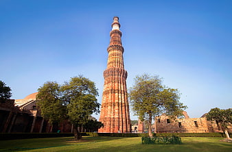 Qutub Minar Tower in Delhi India with Blue Sky and Green Grass