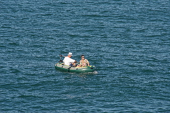 Couple in inflatable boat on blue ocean water