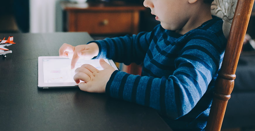 Child Using Tablet at Table