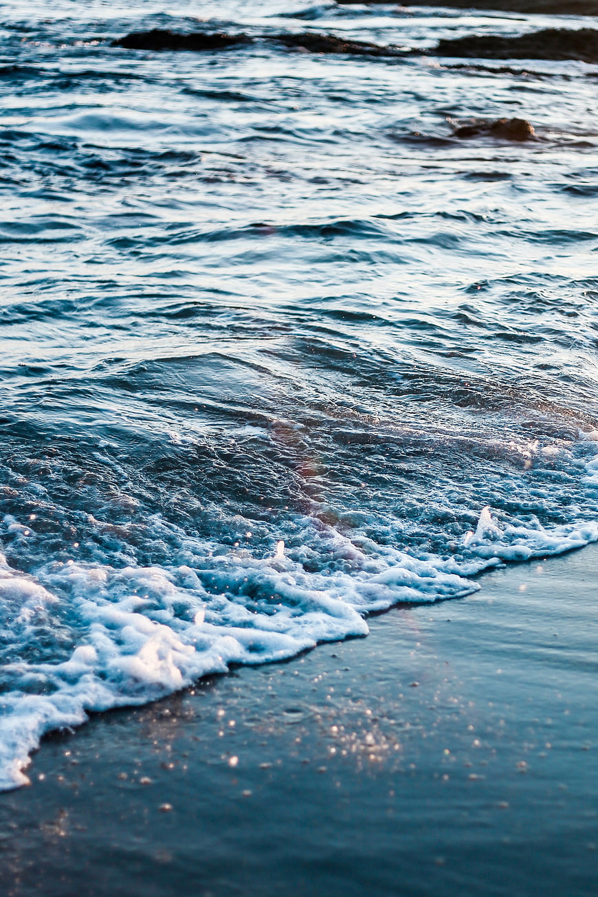 Close-up of ocean waves washing onto a sandy beach