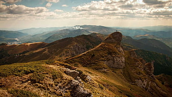 Panoramic Mountain Ridge with Sunbeams and Distant Peaks