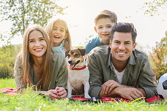 Happy family with dog having a picnic in the park