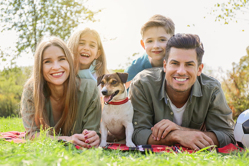 Happy family with dog having a picnic in the park