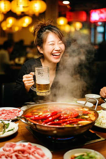 Laughing Woman Enjoying Spicy Hot Pot and Beer
