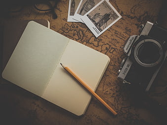 Vintage travel planning setup with notebook, camera, and map