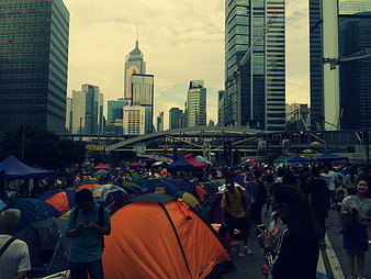 Crowd of people camping with tents in urban city street