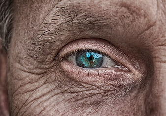 Close-up of elderly man's blue eye with wrinkled skin