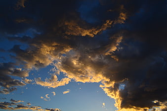 Dramatic golden sunset clouds against deep blue sky