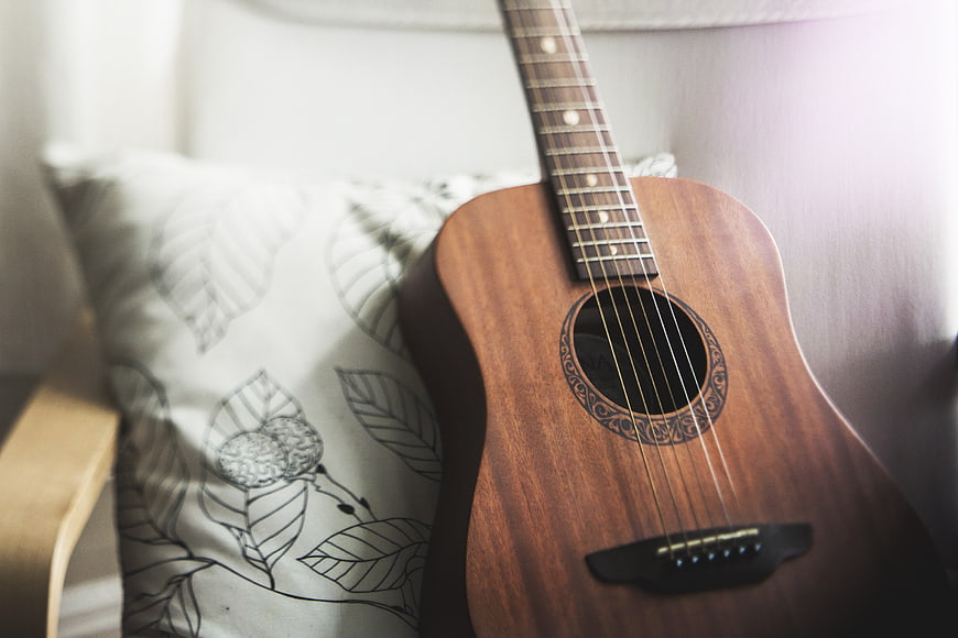 Acoustic Guitar on Chair with Patterned Pillow