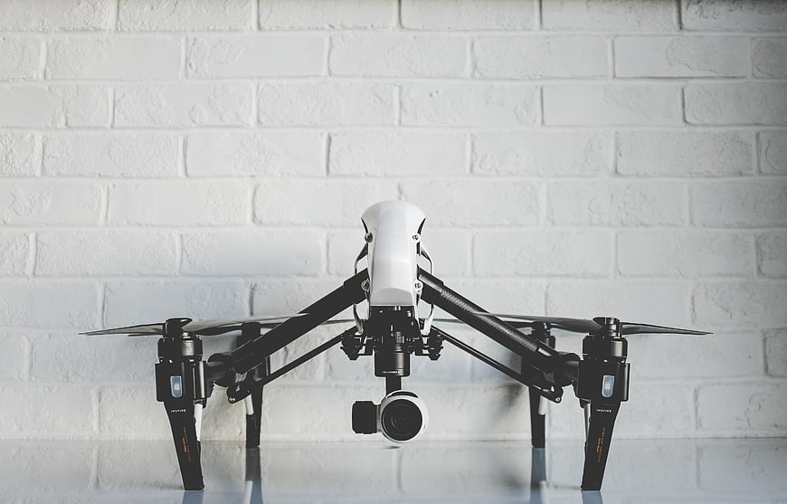 White DJI Inspire Drone on White Brick Wall Background