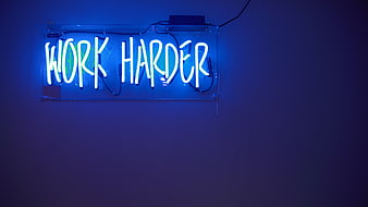 Blue Neon Work Harder Sign on Dark Wall
