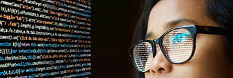 Close-up of woman programmer wearing glasses with code reflection
