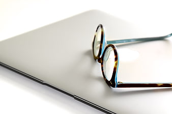 Tortoiseshell Glasses on Closed Silver Laptop