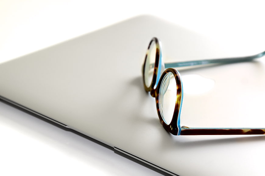 Tortoiseshell Glasses on Closed Silver Laptop