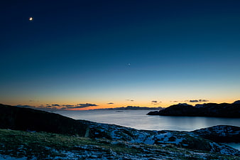Serene Arctic Landscape with Moon and Sunset Horizon