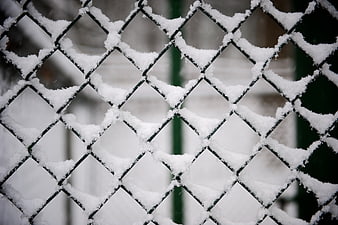 Snow-covered chain-link fence in winter