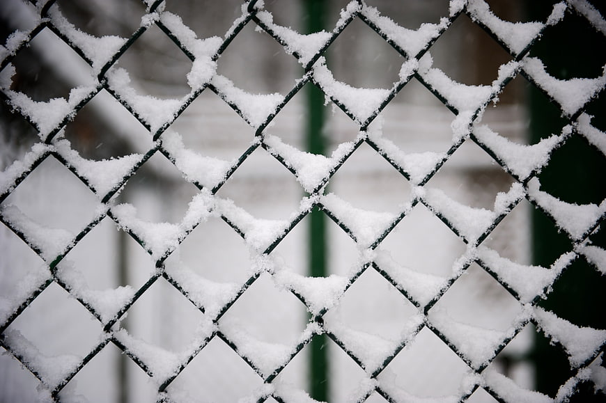 Snow-covered chain-link fence in winter