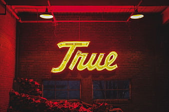 Yellow True Neon Sign on Red Brick Wall