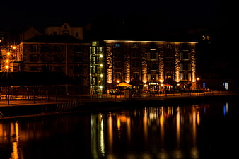 Illuminated Stone Building Reflected in River at Night