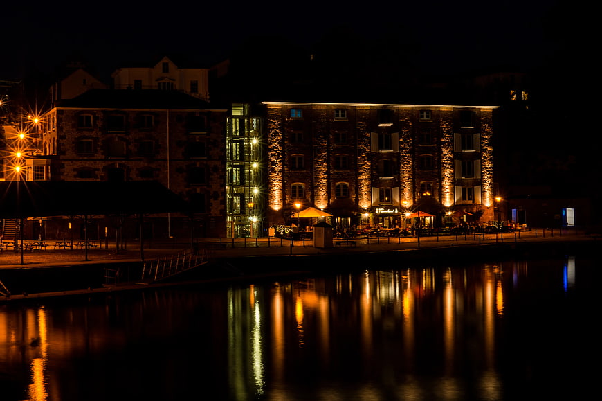 Illuminated Stone Building Reflected in River at Night