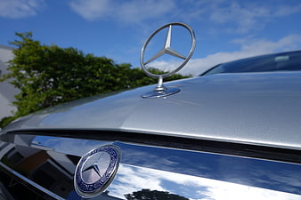 Close-up of Mercedes-Benz hood ornament and grille emblem