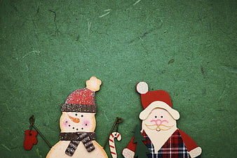 Wooden Santa and Snowman Christmas Ornaments on Green Background