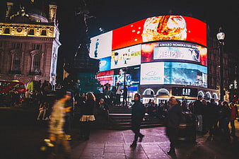 Night view of Piccadilly Circus London with bright billboards and crowd