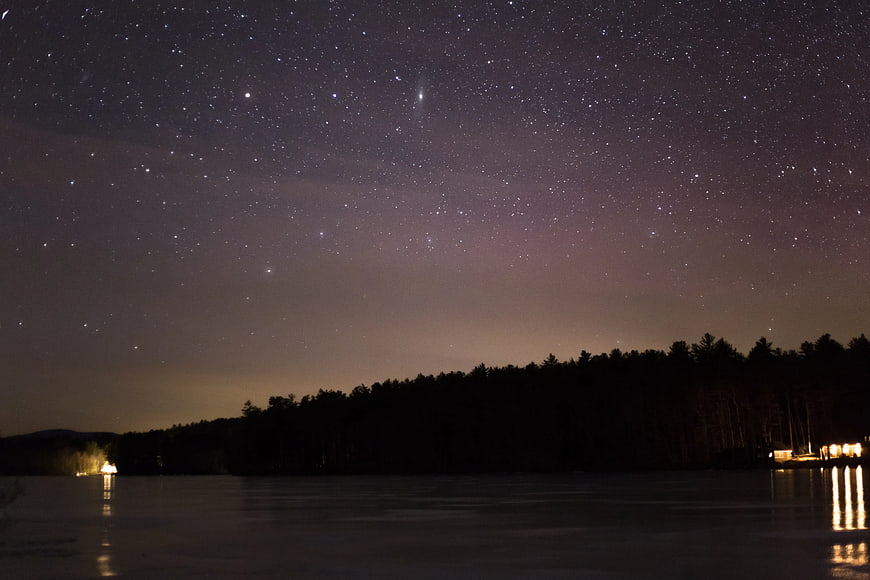 Starry Night Sky Over Lake and Forest Silhouette
