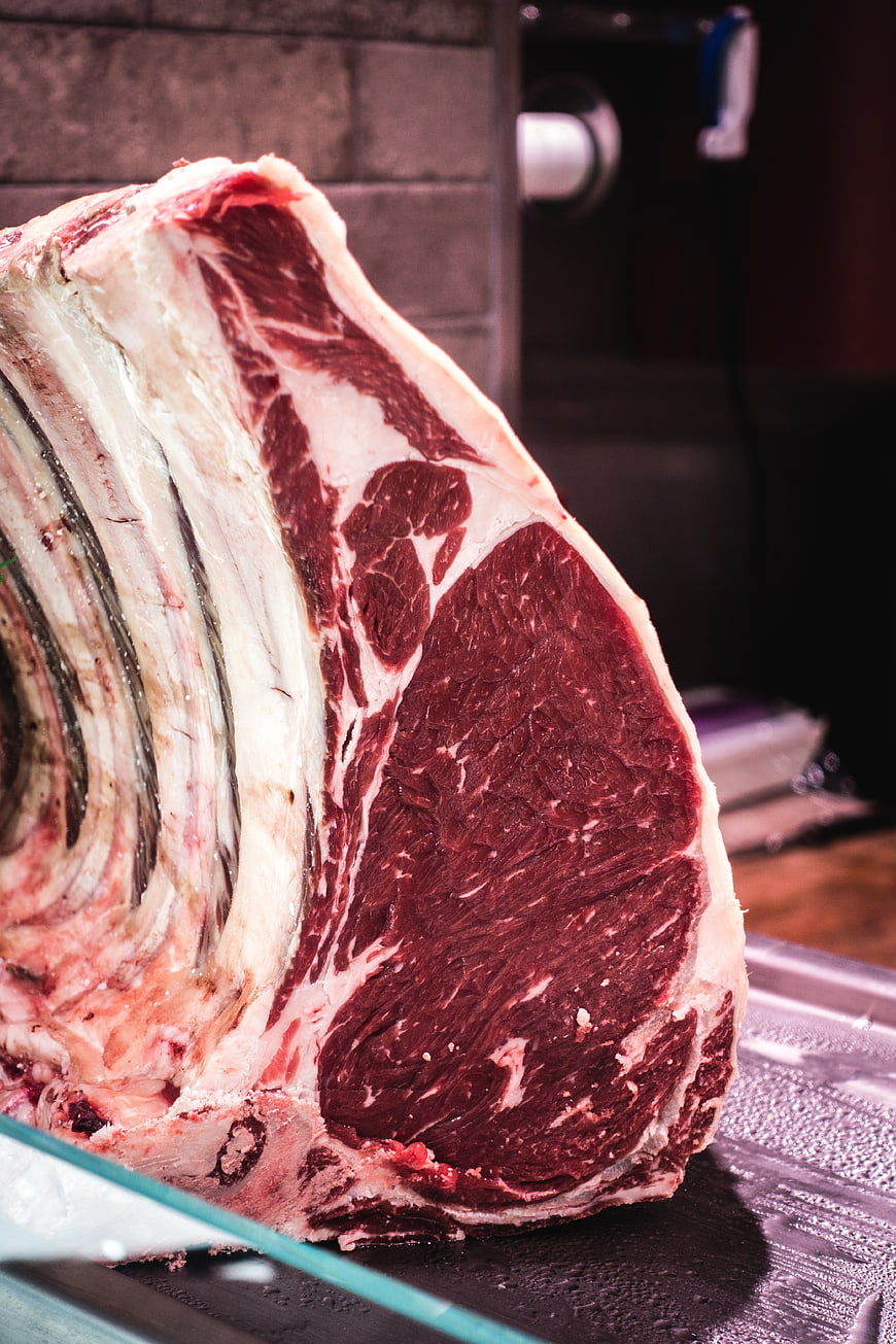Close-up of raw beef ribeye steak with bone