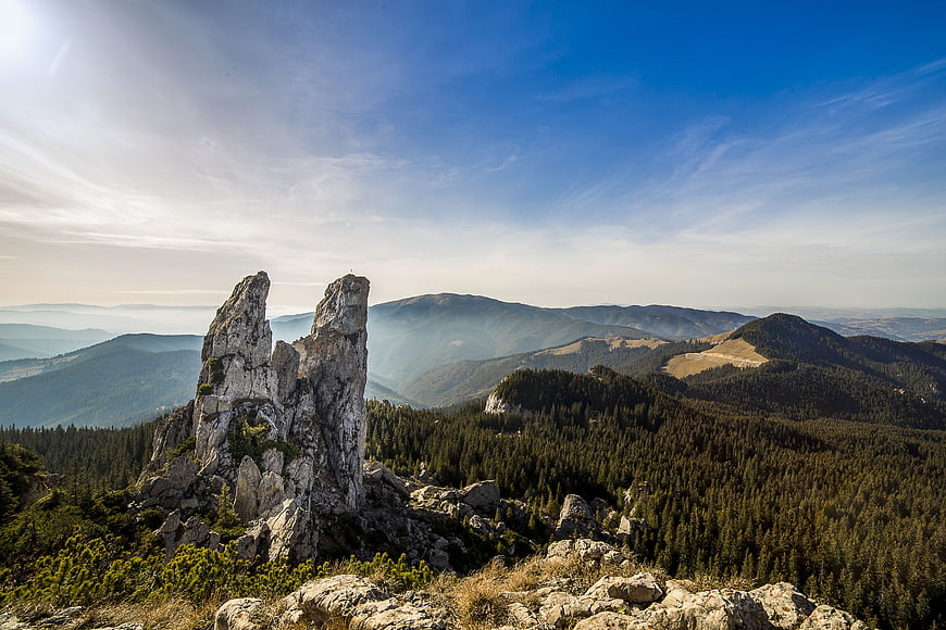 Dramatic rock formation in Carpathian mountains with forest view