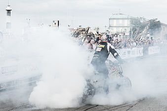 Motorcycle stunt rider performing burnout with smoke