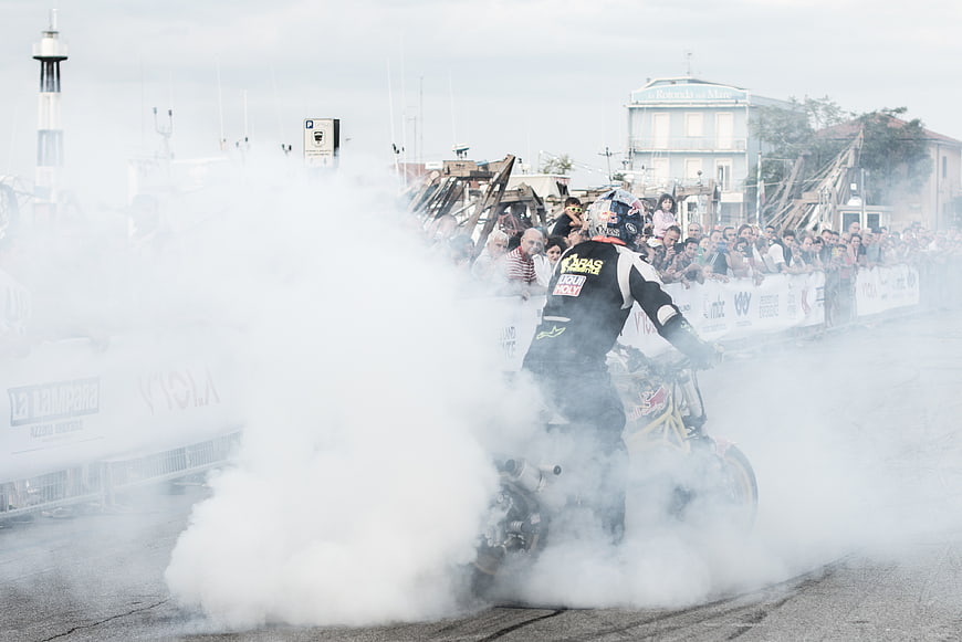 Motorcycle stunt rider performing burnout with smoke