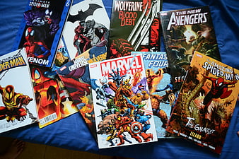 Collection of Marvel and DC comic books on blue background