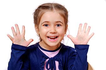 Happy little girl smiling with hands raised white background