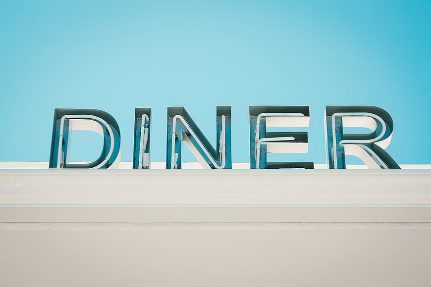 Retro Diner Sign Against Blue Sky