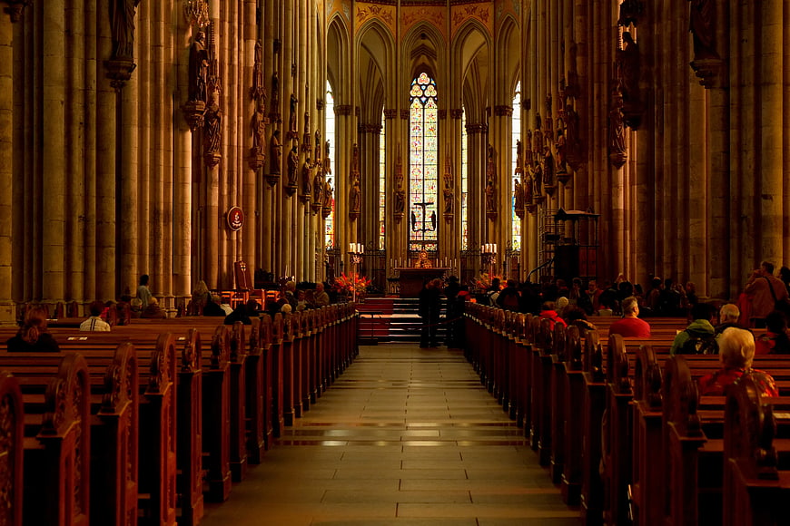 Interior of Gothic Cathedral with Congregation and Stained Glass