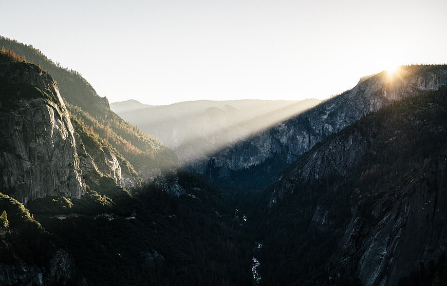 Sunlight Beams Over Mountain Valley at Sunrise