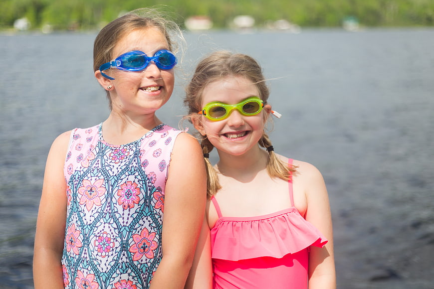 Two Happy Girls in Swimsuits and Goggles by Lake