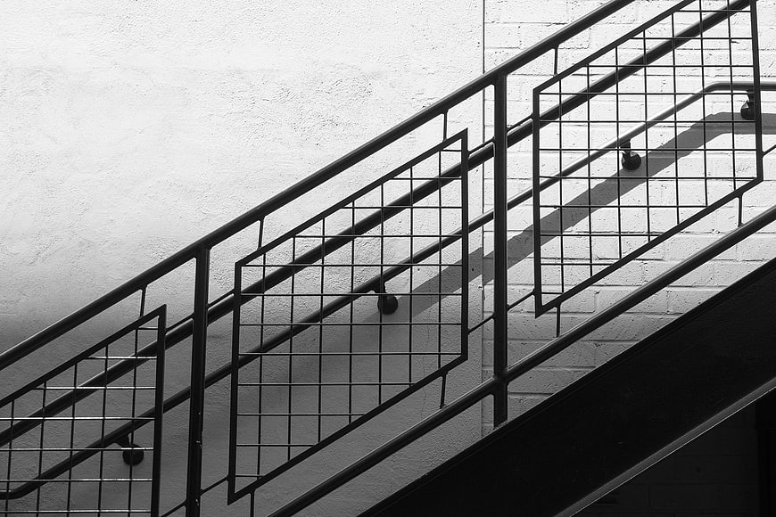Black and white geometric staircase railing shadows