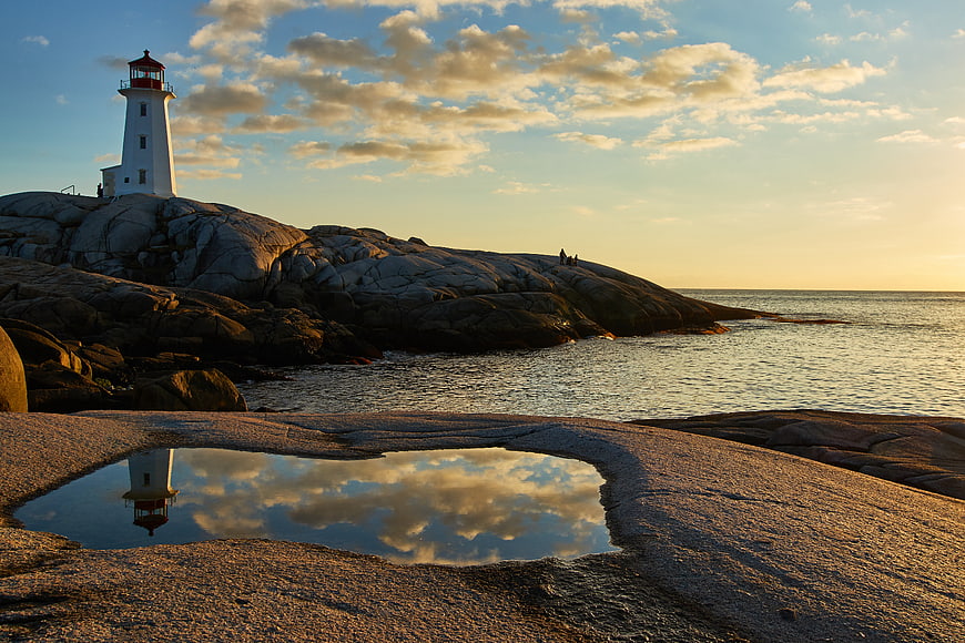 Lighthouse on Rocky Coast with Tide Pool Reflection at Sunset