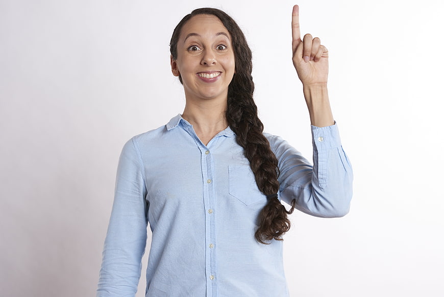 Happy woman pointing finger up with idea