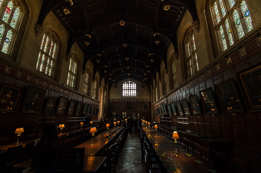 Interior of historic Oxford dining hall with stained glass windows