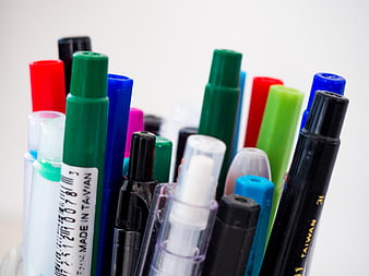 Close-up of colorful markers and pens in a holder