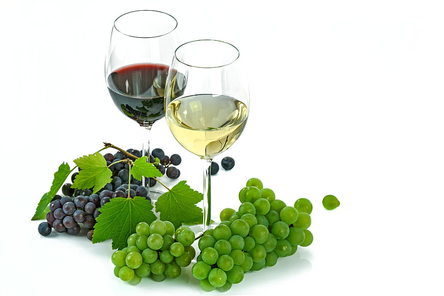 Red and White Wine Glasses with Fresh Grapes on White