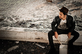 Man in Fedora Playing Drum Sticks on Rooftop